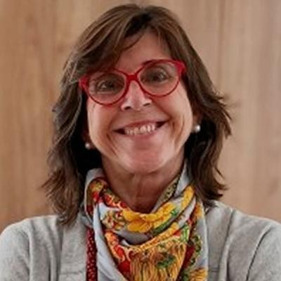 Una mujer que lleva gafas y bufanda sonríe para la cámara.