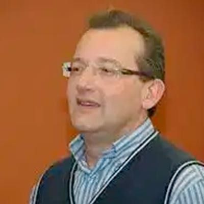 Un hombre que lleva gafas y una camisa de rayas está sonriendo.